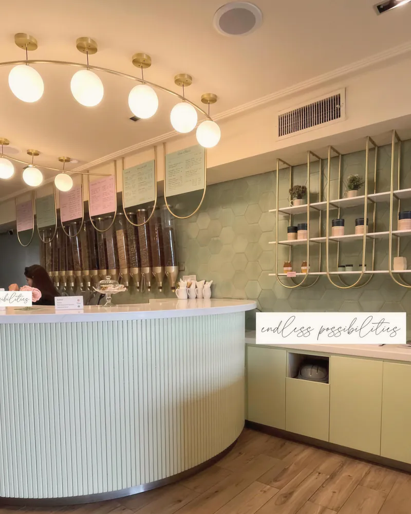A café counter with globe lights and a curved white bar